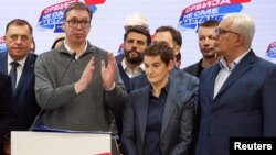Predsednik Skupštine Crne Gore Andrija Mandić (desno) stoji pored premijerke Srbije Ane Brenabić i predsednika Aleksandra Vučića, u izbornom štabu Srpske napredne stranke, tokom proglašenja pobede na parlamentarnim izborima u Srbiji, u Beogradu, 17. decembra 2023.