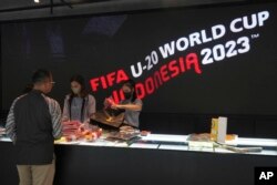 Petugas toko melayani pelanggan yang berbelanja merchandise resmi FIFA U-20 World Cup di sebuah pusat perbelanjaan di Jakarta, Jumat, 31 Maret 2023. (Foto: AP)