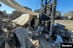 Pengungsi Palestina, yang terpaksa mengungsi akibat serangan militer Israel, duduk di luar tenda mereka, di Rafah, di selatan Jalur Gaza, 13 Mei 2024. (Foto: Reuters)