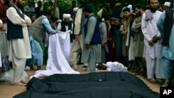 Dead bodies of Afghan people are seen on the ground after heavy flooding in Baghlan province in northern Afghanistan, May 11, 2024. 