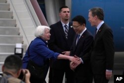 Menteri Keuangan AS Janet Yellen, kiri, berjabat tangan dengan Duta Besar AS untuk China Nicolas Burns saat Wakil Menteri Keuangan China Liao Min melihatnya, di Bandara Guangzhou Baiyun di Guangdong, China selatan, 4 April 2024. (Foto: AP)