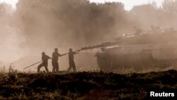 Izraelski vojnici čiste tenk posle povratka iz Pojasa Gaze (Foto: REUTERS/Amir Cohen)