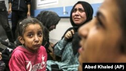 Sejumlah warga Palestina yang terluka akibat ledakan di Rumah Sakit al-Ahli, tampak duduk di lantai Rumah Sakit Al-Shifa di Kota Gaza, 17 Oktober 2023. (AP/Abed Khaled)