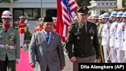 Kepala Staf Angkatan Darat AS Jenderal James McConville (kanan) dan Menteri Pertahanan RI Prabowo Subianto memeriksa pasukan kehormatan dalam pertemuan mereka di Jakarta, Jumat, 12 Mei 2023. (Foto: AP/Dita Alangkara)