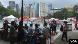 People gather near a soccer field which in previous years had been used annually for vigils to mark the 1989 Tiananmen Square crackdown, at Victoria Park, Hong Kong, June 4, 2024. This year, the venue was blocked off for a carnival by pro-government groups. (Cindy Sui/VOA)