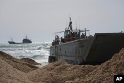 FILE - A U.S. Army landing craft is seen beached in Ashdod, May 26, 2024, after being swept from the temporary pier off the Gaza Strip. The pier, designed to carry aid into Gaza, has been reconnected to the beach, U.S. Central Command said June 7.
