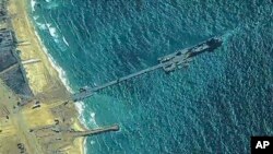 The image provided by U.S, Central Command shows U.S. soldiers and sailors and members of the Israel Defense Forces placing the Trident Pier on the coast of Gaza Strip, May 16, 2024.