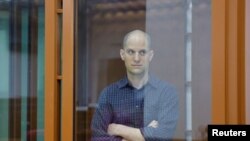 Wartawan Wall Street Journal Evan Gershkovich terlihat berada dalam ruang kaca khusus untuk terdakwa di dalam ruang sidang pada persidangan kasus dugaan spionase yang membelitnya di Yekaterinburg, Rusia, pada 26 Juni 2024. (Foto: Reuters/Evgenia Novozhenina)