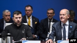 Ukrainian President Volodymyr Zelenskyy and German Chancellor Olaf Scholz react prior to the start of a working session during the Ukraine Recovery Conference in Berlin on June 11, 2024.