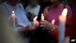 People hold candles as they attend a vigil in front of a synagogue in Berlin, Germany, Oct. 13, 2023.