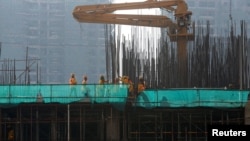 FILE: Labourers work at a construction site in Phnom Penh, Cambodia, June 3, 2019. 