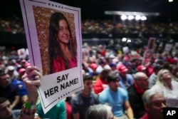 FILE - A supporter holds a poster with a photo of Laken Riley before Republican presidential candidate Donald Trump speaks at a campaign rally on March 9, 2024, in Rome, Georgia.