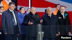 Presiden Rusia Vladimir Putin dalam konferensi pers bersama ketiga rivalnya dalam pilpres Rusia, di Lapangan Merah, Moskow, Senin (18/3). 