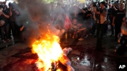 Supporters of Thailand's Move Forward Party burn an effigy during a protest at Pheu Thai party headquarters in Bangkok on Aug. 2, 2023.