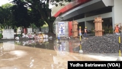 Para pekerja merenovasi pagar besi di area pintu gerbang menuju akses masuk stadion Manahan Solo, Selasa (14/2). (Foto: VOA/Yudha Satriawan)