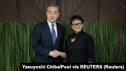 Menteri Luar Negeri China Wang Yi dan Menteri Luar Negeri Retno Marsudi berjabat tangan saat bertemu di Jakarta, 18 April 2024. (Foto: Yasuyoshi Chiba/Pool via REUTERS)