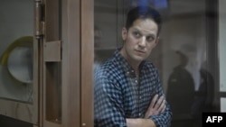 American journalist Evan Gershkovich, arrested on espionage charges, stands inside a defendants' cage before a hearing to consider an appeal on his arrest, at the Moscow City Court in Moscow, Apr. 18, 2023