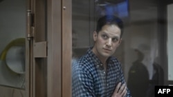 FILE - U.S. journalist Evan Gershkovich, arrested on espionage charges, stands inside a defendants' cage before a hearing to consider an appeal on his arrest at the Moscow City Court in Moscow, April 18, 2023.