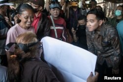 Wali Kota Surakarta Gibran Rakabuming Raka, putra sulung Presiden Indonesia Joko Widodo, berbincang dengan seorang aktivis di Surakarta, Jawa Tengah, 16 Oktober 2023. (Antara Foto/Mohammad Ayudha/via REUTERS)