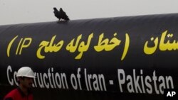 FILE - An Iranian worker walks past the Pakistan-Iran Gas Pipeline Project in Gabd near the Pakistani border in Iran, March 11, 2013.