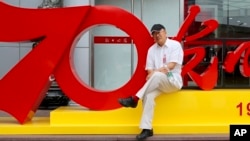 FILE - In this photo provided by the Dong family, veteran Chinese journalist Dong Yuyu poses for a photo in Beijing in June 2019.