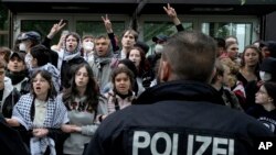 Polisi Jerman berhadapan dengan kelompok "Koalisi Mahasiswa Berlin" yang berunjuk rasa Pro-Palestina di halaman teater universitas 'Freie Universität Berlin' di Berlin, Jerman, Selasa, 7 Mei 2024. (AP/Markus Schreiber)