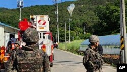 29일 한국 무주에서 북한이 보낸 것으로 추정되는 쓰레기가 담긴 풍선이 전선에 매달려 있다.