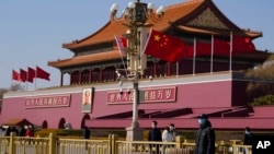 A plainclothes security person keeps watch near Tiananmen Gate ahead of the annual Congress in Beijing, March 2, 2023.