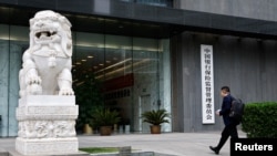 资料照:一名男子走向北京的中国银行保险监督管理委员会. (2023年4月20日)