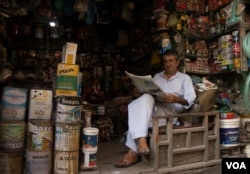 Local resident on the Indian side of Kashmir reads newspaper while sitting in from of a shop in Srinagar—the capital city of the region. (Wasim Nabi/VOA)