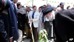 Iran's President Ebrahim Raisi, right, plants a mango tree with Pakistan's Prime Minister Shahbaz Sharif, center, during an inauguration of the Mand-Pishin border in Pishin, May 18, 2023. (Pakistan Prime Minister Office via AP)