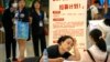 FILE - A recruiter talks with an applicant at a booth at a job fair at a shopping center in Beijing, on June 9, 2023. High youth unemployment is one sign that China's economy is still struggling. 
