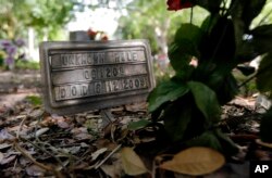 FILE - A marker with "Unknown Male" marks the grave of an unidentified migrant, at a cemetery in Falfurrias, Texas, June 25, 2014.