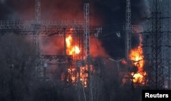 Smoke and fire are seen around high-voltage lines at a site of a Russian missile strike, amid Russia's attack on Ukraine, outside Kharkiv, Ukraine, March 22, 2024.
