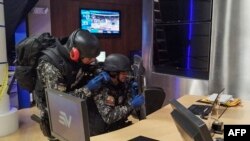 This photo released by Ecuador's National Police shows police officers searching for explosives after a device detonated at the Ecuavisa channel premises in Guayaquil, Ecuador on March 20, 2023.
