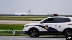 资料照：上海浦东国际机场的一架飞机和一辆中国公安警车（2023年10月7日）