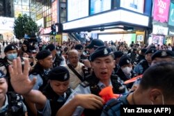 Artis Sanmu Chan diamankan polisi di Causeway Bay dekat Victoria Park di Hong Kong, 3 Juni 2023, atau satu hari sebelum peringatan tragedi penumpasan gerakan pro-demokrasi di Lapangan Tiananmen, China, pada 1989. (Foto: Yan Zhao/AFP)