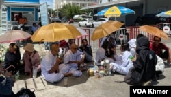 សកម្មជនមាតាធម្មជាតិនិងអ្នកគាំទ្រអង្គុយនៅមុខរបាំងឃាំងរបស់កងកម្លាំងសន្តិសុខនៅច្រកចូលសាលាដំបូងរាជធានីភ្នំពេញ នៅថ្ងៃទី៥ ខែមិថុនា ឆ្នាំ២០២៤។ (ចិត្ត ស្រីយ៉ា/វីអូអេ)
