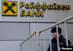 Seorang polisi Rusia berdiri di depan cabang Bank Raiffeisen di Moskow, Rusia, 27 Februari 2016. (Foto: REUTERS/Maxim Shemetov)