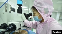 Seorang pekerja tampak memeriksa kondisi wafer dalam lini produksi pembuatan semikonduktor di sebuah perusahaan cip di Suqian, provinsi Jiangsu, China, pada 28 Februari 2023. (Foto: China Daily via Reuters)