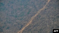 FILE - Aerial image of an area of deforested Amazon rainforest covered in smoke from an illegal fire in the municipality of Cujubim, Rondonia State, northern Brazil, Aug. 20, 2024.