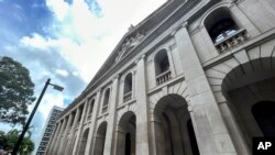 FILE - Seorang perempuan melihat dokumen di luar Pengadilan Banding Terakhir Hong Kong di Hong Kong, 22 Agustus 2023. (AP/Kanis Leung)