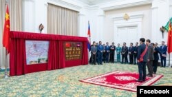 នាយករដ្ឋមន្ត្រីកម្ពុជាលោក ហ៊ុន ម៉ាណែត និងអគ្គរដ្ឋទូតចិនប្រចាំកម្ពុជាលោក Wang Wentian ឈរ​ក្នុងពិធី​សម្ពោធជានិមិត្តរូបក្នុងការប្រសិទ្ធនាមផ្លូវ «មហាវិថី ស៊ី ជីនពីង» រាជធានីភ្នំពេះ កាលពីថ្ងៃទី ២៨ ខែឧសភា ឆ្នាំ២០២៤។ (Facebook / Chinese Embassy in Cambodia)