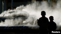 FILE - Two children look at a sculpture called 'Shell' but nicknamed by locals
as 'Steaming Dog Poo' in Sydney.