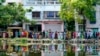 People queue up to vote outside a polling booth during the fifth round of multi-phase national election in Howrah, India, May 20, 2024.