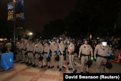 Petugas Patroli Jalan Raya California berbaris saat pengunjuk rasa bentrok dengan pengunjuk rasa yang mendukung warga Palestina di Gaza di Universitas California, Los Angeles (UCLA) di Los Angeles, California, AS, 1 Mei 2024 (Foto: REUTERS/David Swanson)