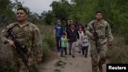 德州国民自卫队成员押解一批来自中国和南美穿越美墨边境进入美国的非法移民。(2023年4月5日)
