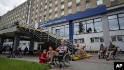 Ukrainian army veterans rest with their families and comrades outside St. Panteleimon hospital in Lviv, Ukraine, July 25, 2023.