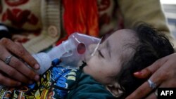 រូបឯកសារ៖ ស្ត្រីជាម្តាយ​ជួយ​កូនស្រីឱ្យដកដង្ហើមដោយប្រើម៉ាស៊ីនជំនួយនៅឯមន្ទីរសង្គ្រោះបន្ទាន់នៅពេទ្យកុមារ Chacha Nehru Bal Chikitsalaya នៅក្រុងញូវដែលី ប្រទេសឥណ្ឌា កាលពីថ្ងៃទី៧ ខែវិច្ឆិកា ឆ្នាំ២០២៣។ (AFP)