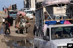 Orang-orang Palestina menyelamatkan diri menuju selatan melalui Deir al Balah di tengah serangan darat Israel di tengah Jalur Gaza, Jumat, 5 Januari 2024. (Foto: Adel Hana/AP Photo)